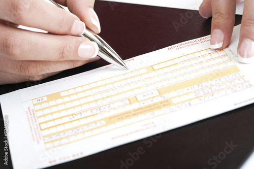 Foto: Person filling in a money transfer form Person filling in a money transfer form