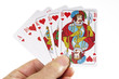 Person holding royal flush of hearts suit, close-up