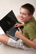 Boy learning at home with notebook and showing OK.