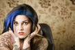 Pretty young woman with many tattoos in a leather chair Pretty young woman with many tattoos in a leather chair