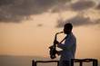 Man playing  saxophone at sunset