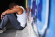 Depressed or sad young man sitting on the ground Depressed or sad young man sitting on the ground