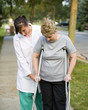 physical therapist helps a woman on crutches