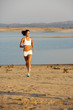 A woman running down a path at the beach A woman running down a path at the beach