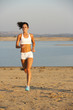 A woman running down a path at the beach A woman running down a path at the beach