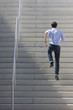 A young, dynamic man is running upstairs.