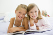 Photo: Two Young Girls In Their Pajamas, Reading A Book Two Young Girls In Their Pajamas, Reading A Book