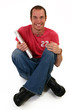 Man on floor with laptop smiling.