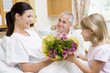Photographie : Young Girl Giving Flowers To Her Mother In Hospital