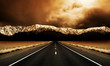 Long straight road heading to stormy mountains
