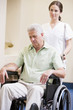 Nurse Pushing Man In Wheelchair