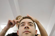 A young man getting his hair cut by a hairdresser at a salon