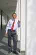 Geschäftsmann steht vor einem Bürogebäude