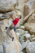 Rock climber clinging to an overhang.