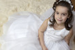 Portrait of a little girl in communion dress and veil.