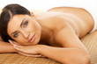 Beautiful brunette woman laying on bamboo mat