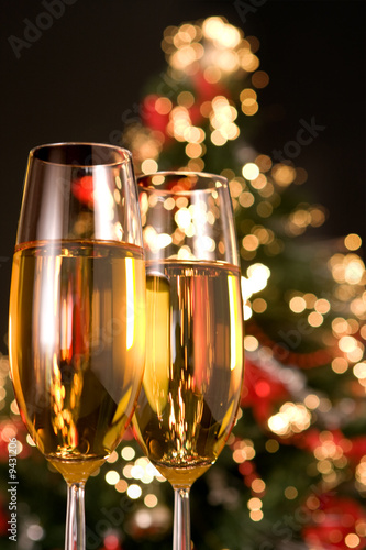 Photo: Blurred christmas tree and two champagne glasses Blurred christmas tree and two champagne glasses