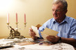 Senior man looking at old photographs. Reminisce