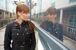 Teenage girl looking at her own reflection in window