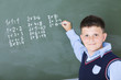 A boy does multiplication on chalkboard