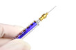 Gloved hand holding a blue syringe with clipping path included.