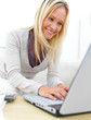 Portrait of a young girl sitting on sofa and using laptop