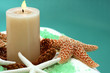 Candle and spa item on white towel