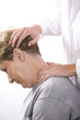 physical therapist examines a patient's neck