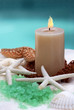Candle and spa item on white towel