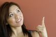 Young Asian woman pointing to copy space area