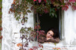 Portrait of beautiful girl through the old window