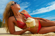 Girl with coconut on white sand beach