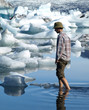 Man, wading between icebergs in Jokulsarlon lagoon, Iceland