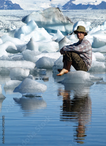 Foto: Man, sitting on ice in Jokulsarlon lagoon, Iceland Man, sitting on ice in Jokulsarlon lagoon, Iceland