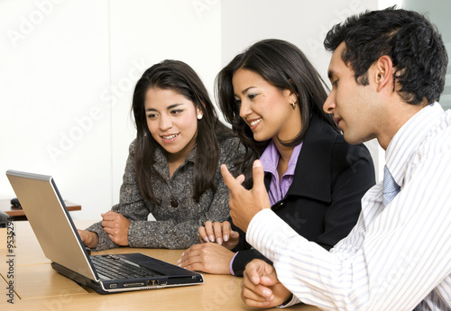 business team browsing on a laptop - smiling business team browsing on a laptop - smiling