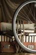 Bicycle wheel and Old torn suit-case full of books with rope