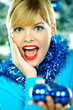 Foto: Beautiful young woman next to christmas tree Beautiful young woman next to christmas tree