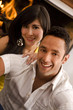 Beautiful couple in love smiling in front of the fireplace