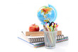 box with pencils spiral netebook and red apple on white