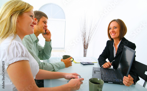 businesswoman showing laptop to professional couple