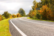 Autumn road. Green and yellow trees. Sun weather