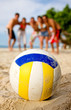 beach volleyball ball at the beach with the team behind