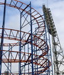 Attraction a roller coaster, the big fixture and the blue sky.