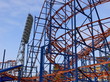 Attraction a roller coaster, the big fixture and the blue sky.