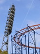 Attraction a roller coaster, the big fixture and the blue sky.