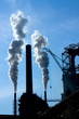 Steel factory with chimneys and white smoke