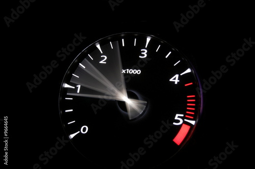 Photo: moving revs meter of a sports car on a black background. moving revs meter of a sports car on a black background.