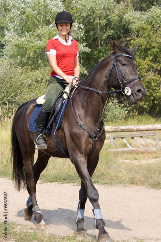 Photo: Smiling girl riding on horse Smiling girl riding on horse