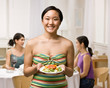 Woman holding salad about to join friends for dinner party