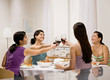 Friends toasting with red wine at dinner party